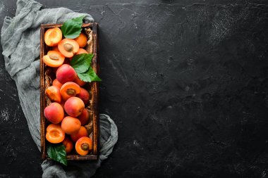 Bir kutuda yeşil yaprakları ile taze kayısı. Rustik tarz. Üst te. Metniniz için boş alan.