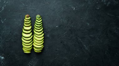 Siyah bir arka plan üzerinde dilimlenmiş avokado ve baharatlar. Rustik tarz. Üst te. Metniniz için boş alan.