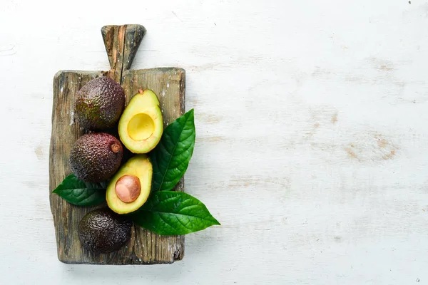 Avokado Och Gröna Blad Vit Trä Bakgrund Rustik Stil Översta — Stockfoto