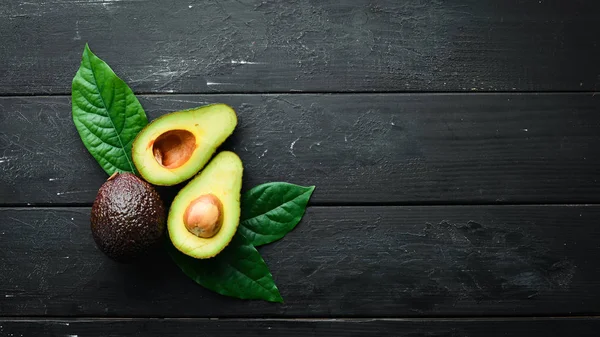 Verse Avocado Met Bladeren Een Zwarte Achtergrond Bovenaanzicht Vrije Ruimte — Stockfoto