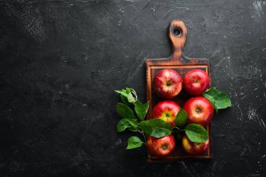 Siyah bir arka plan üzerinde yeşil yaprakları ile Taze kırmızı elma. Meyve. Üst te. Metin için boş alan.