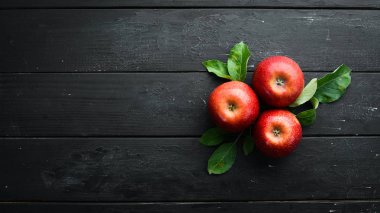 Siyah bir arka plan üzerinde yeşil yaprakları ile Taze kırmızı elma. Meyve. Üst te. Metin için boş alan.