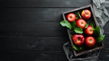 Siyah bir arka plan üzerinde yeşil yaprakları ile Taze kırmızı elma. Meyve. Üst te. Metin için boş alan.