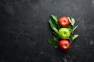 Siyah bir arka plan üzerinde yeşil yaprakları ile renkli elma. Meyve. Üst te. Metin için boş alan.