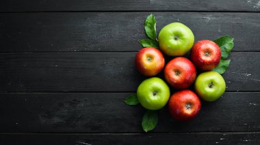 Siyah bir arka plan üzerinde yeşil yaprakları ile renkli elma. Meyve. Üst te. Metin için boş alan.