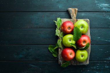 Siyah bir arka plan üzerinde yeşil yaprakları ile renkli elma. Meyve. Üst te. Metin için boş alan.