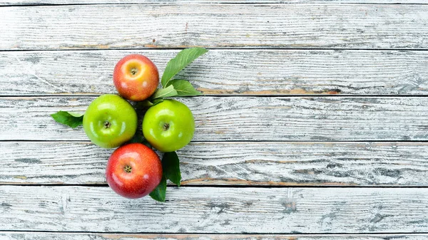 Colored apples on a white wooden background. Fruits. Top view. Free space for text.