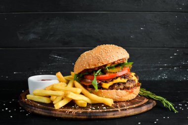 Dana eti, peynir ve sebzeli burger. Fast food. Ahşap bir arka plan üzerinde. Üst te. Metniniz için boş alan.