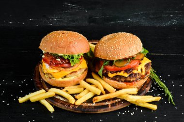 Dana eti, peynir ve sebzeli burger. Fast food. Ahşap bir arka plan üzerinde. Üst te. Metniniz için boş alan.