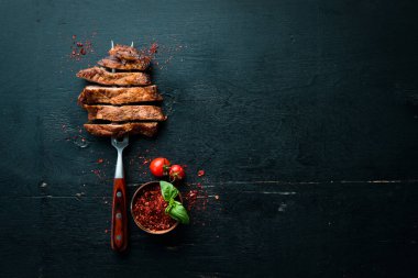 Çatalda domuz bifteği. Ahşap bir arka plan üzerinde. Üst te. Metniniz için boş alan.