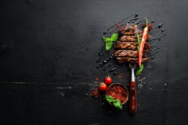 Çatalda domuz bifteği. Ahşap bir arka plan üzerinde. Üst te. Metniniz için boş alan.