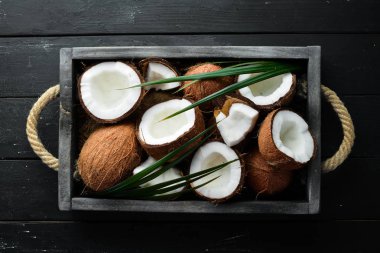 Tahta bir kutuda hindistan cevizi. Tropikal Meyveler. Somun. Üst te. Metniniz için boş alan.