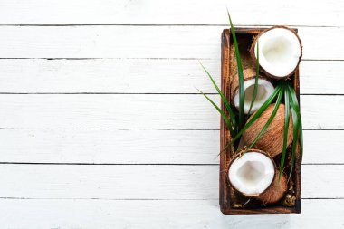 Tahta bir kutuda hindistan cevizi. Tropikal Meyveler. Somun. Üst te. Metniniz için boş alan.