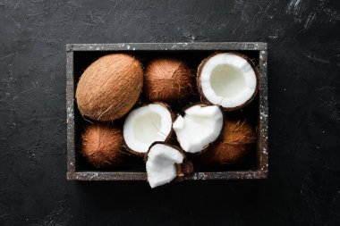 Tahta bir kutuda hindistan cevizi. Tropikal Meyveler. Somun. Üst te. Metniniz için boş alan.