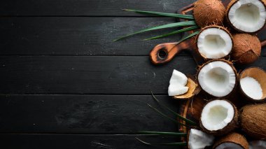 Siyah bir arka plan üzerinde taze hindistan cevizi. Tropikal Meyveler. Somun. Üst te. Metniniz için boş alan.