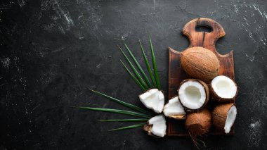 Siyah bir arka plan üzerinde taze hindistan cevizi. Tropikal Meyveler. Somun. Üst te. Metniniz için boş alan.