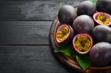 Siyah bir arka plan üzerinde yaprakları ile Passion meyve. Tropikal Meyveler. Üst te. Metin için boş alan.