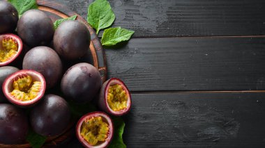 Siyah bir arka plan üzerinde yaprakları ile Passion meyve. Tropikal Meyveler. Üst te. Metin için boş alan.