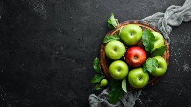 Siyah bir arka plan üzerinde yeşil yaprakları ile renkli elma. Meyve. Üst te. Metin için boş alan.