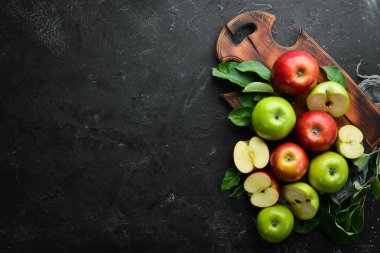 Siyah bir arka plan üzerinde yeşil yaprakları ile renkli elma. Meyve. Üst te. Metin için boş alan.