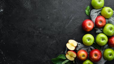 Siyah bir arka plan üzerinde yeşil yaprakları ile renkli elma. Meyve. Üst te. Metin için boş alan.