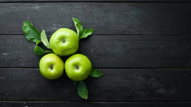 Siyah bir arka plan üzerinde yeşil yaprakları ile Taze yeşil elma. Meyve. Üst te. Metin için boş alan.