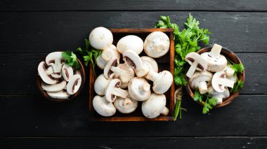 Mantarlar siyah bir masa yüzeyinde dilimlenmiş. Üst te. Metin için boş alan.