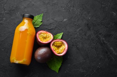 Tutku meyve suyu ve meyve siyah bir arka plan üzerinde. Tropikal Meyveler. Üst te. Metin için boş alan.