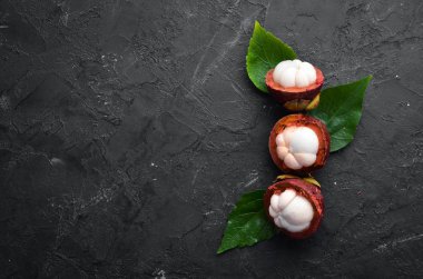 Siyah taş arka plan üzerinde bir yaprak ile Mangosteen. Tropikal Meyveler. Üst te. Metin için boş alan.