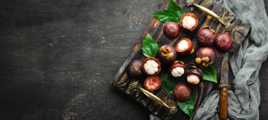 Siyah taş arka plan üzerinde bir yaprak ile Mangosteen. Tropikal Meyveler. Üst te. Metin için boş alan.