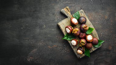 Tropikal meyveler, ahşap bir arka plan üzerinde Mangosteen. Üst te. Metin için boş alan.