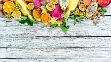 Tropikal meyveler - Maracuya, ananas, ejderha meyve, kivi ve kaktüs beyaz bir arka plan üzerinde. Üst te. Metin için boş alan.