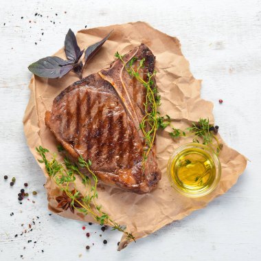 Beyaz bir masada Orta nadir Izgara T-Bone Steak. Üst te. Metin için boş alan.