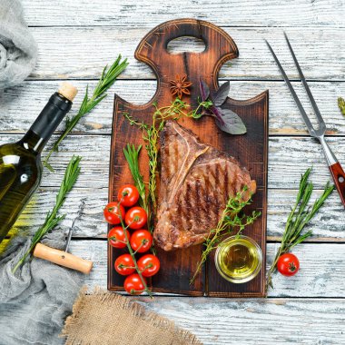 Beyaz bir masada Orta nadir Izgara T-Bone Steak. Üst te. Metin için boş alan.