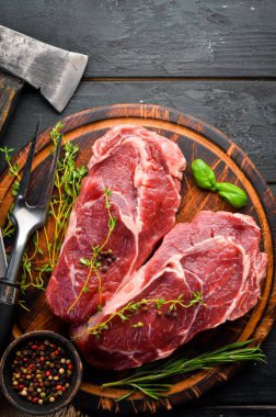 Çiğ Biftek Ribeye. Siyah taş bir masanın üzerinde. Üst te. Metniniz için boş alan.