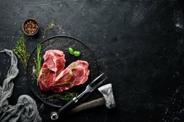 Çiğ Biftek Ribeye. Siyah taş bir masanın üzerinde. Üst te. Metniniz için boş alan.