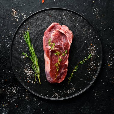 Çiğ Biftek Ribeye. Siyah taş bir masanın üzerinde. Üst te. Metniniz için boş alan.