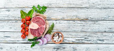 Beyaz bir arka plan üzerinde baharat ve otlar ile Ham taze çapraz kesilmiş dana sapı. Peynirli Bif bif Ossbo. Üst te. Metniniz için boş alan.