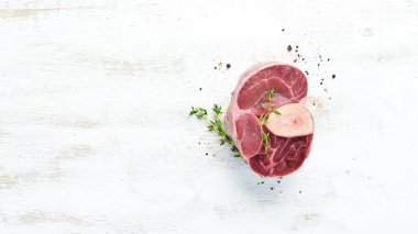 Beyaz bir arka plan üzerinde baharat ve otlar ile Ham taze çapraz kesilmiş dana sapı. Peynirli Bif bif Ossbo. Üst te. Metniniz için boş alan.
