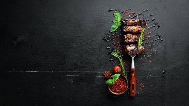 Çatalda domuz pirzolası var. Ahşap bir arka plan üzerinde. Üst te. Metniniz için boş alan.