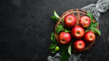 Siyah bir arka plan üzerinde yeşil yaprakları ile Taze kırmızı elma. Meyve. Üst te. Metin için boş alan
