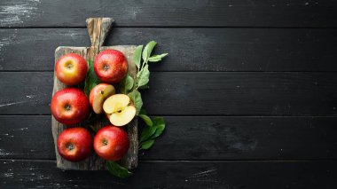 Siyah bir arka plan üzerinde yeşil yaprakları ile Taze kırmızı elma. Meyve. Üst te. Metin için boş alan