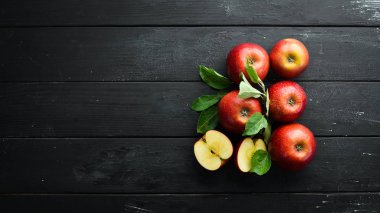 Siyah bir arka plan üzerinde yeşil yaprakları ile Taze kırmızı elma. Meyve. Üst te. Metin için boş alan