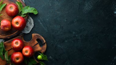 Siyah bir arka plan üzerinde yeşil yaprakları ile Taze kırmızı elma. Meyve. Üst te. Metin için boş alan