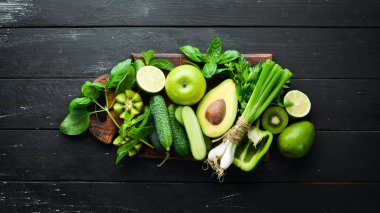 Taze Yeşil Meyve ve Sebzeler. Ahşap yaşlı bir arka plan üzerinde saf seçim ve bitkisel protein kaynağı. Avokado, üzüm, salatalık, kivi, elma, limon, yeşil biber.