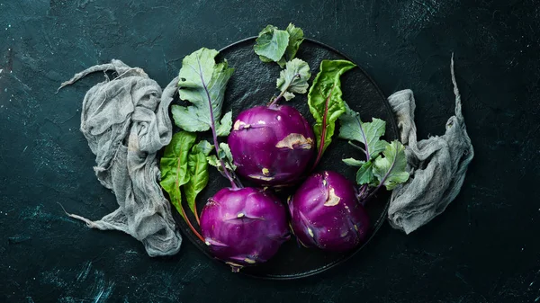 Mor kohlrabi lahanası. Siyah taş bir arka plan üzerinde. Üst te. Metniniz için boş alan.