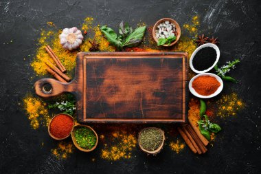 Pişirmek için renkli otlar ve baharatlar. Hint baharatları. Siyah taştan bir arka planda. Üst görünüm.