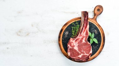 Beyaz ahşap arka planda çiğ kovboy bifteği ve baharatlar. Bbq Top görünümü. Metin için boş alan.