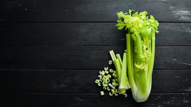 Siyah bir arka plan üzerinde taze yeşil kereviz sapı. Sağlıklı yiyecekler. Üst te. Metniniz için boş alan.