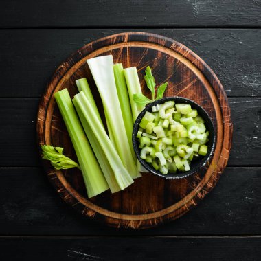 Siyah bir arka plan üzerinde taze yeşil kereviz sapı. Sağlıklı yiyecekler. Üst te. Metniniz için boş alan.